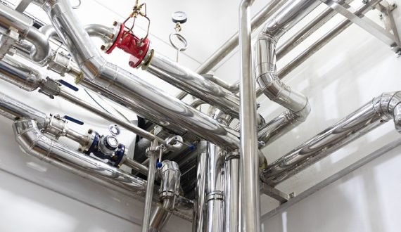 Modern industry equipment, cables and piping inside in manufacture background